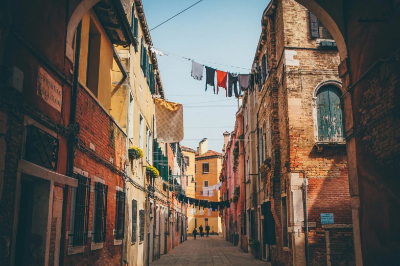 a narrow alley way with washing on the line