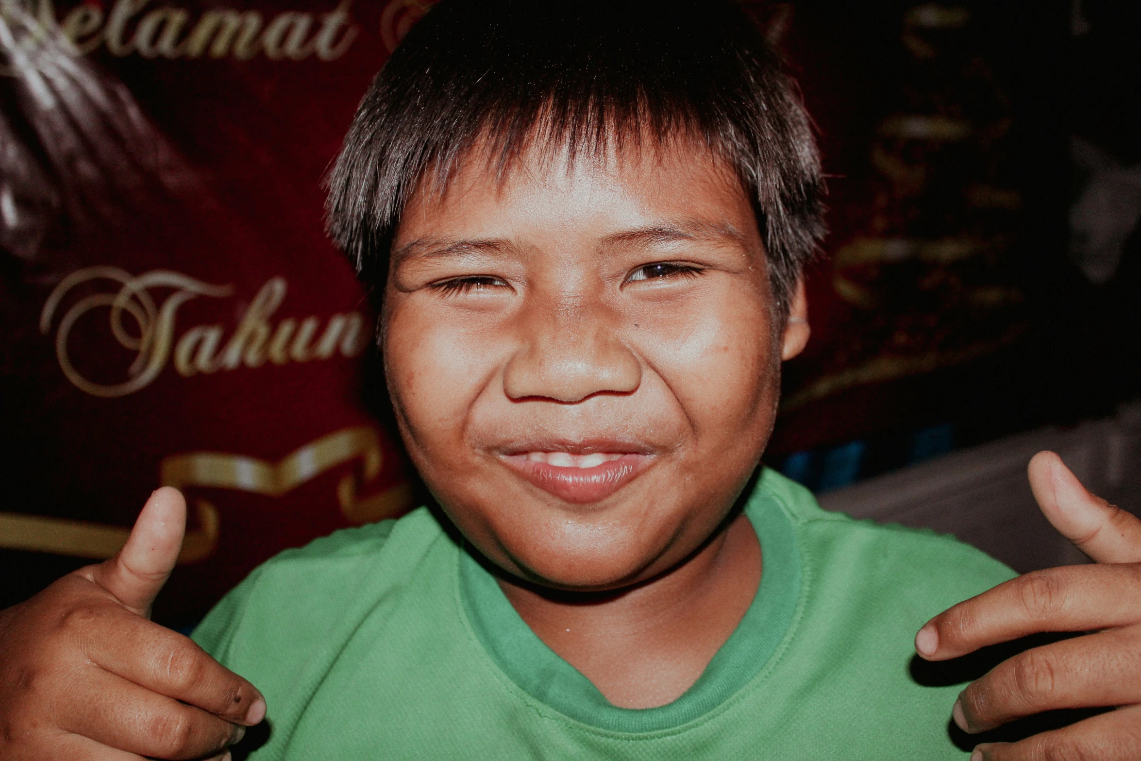 a young man making a thumbs up sign