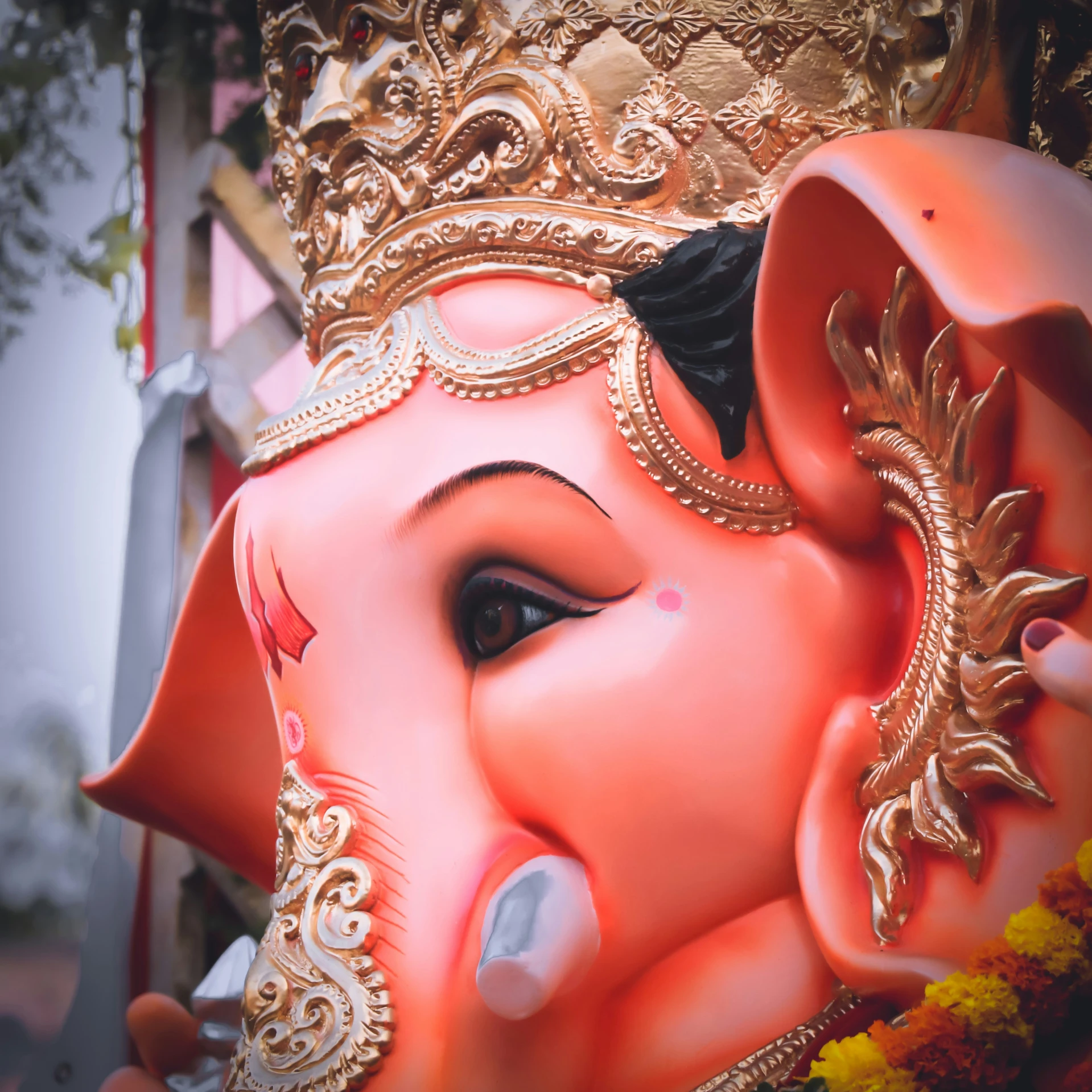 an intricate painted pink elephant head on display