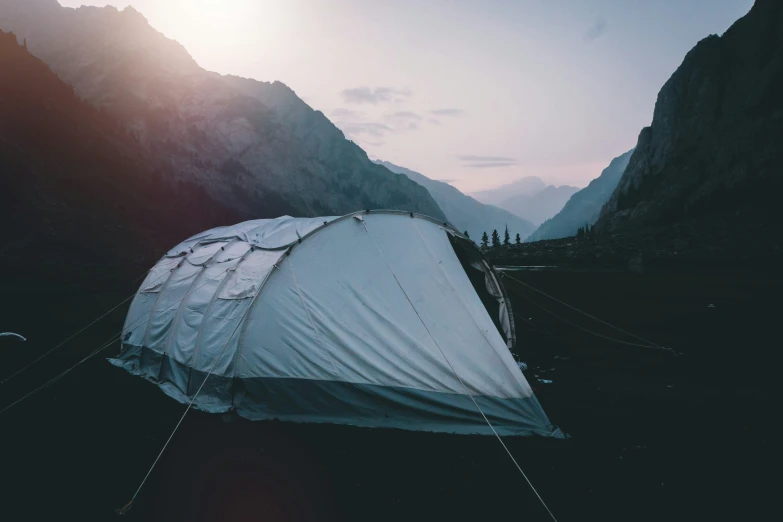 the tent sits near a mountain side and appears to be camp