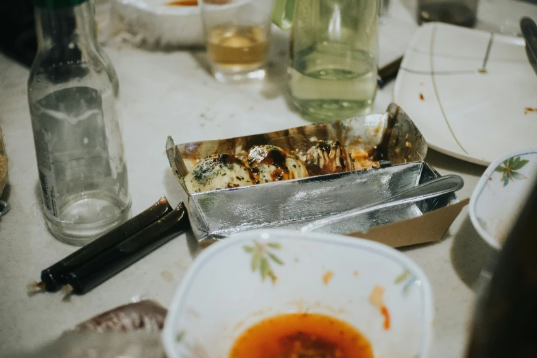 several empty dishes and small pieces of tin foil on a table