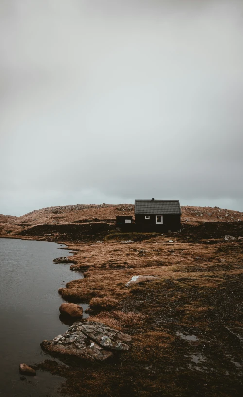 a house is near a body of water on the mountains