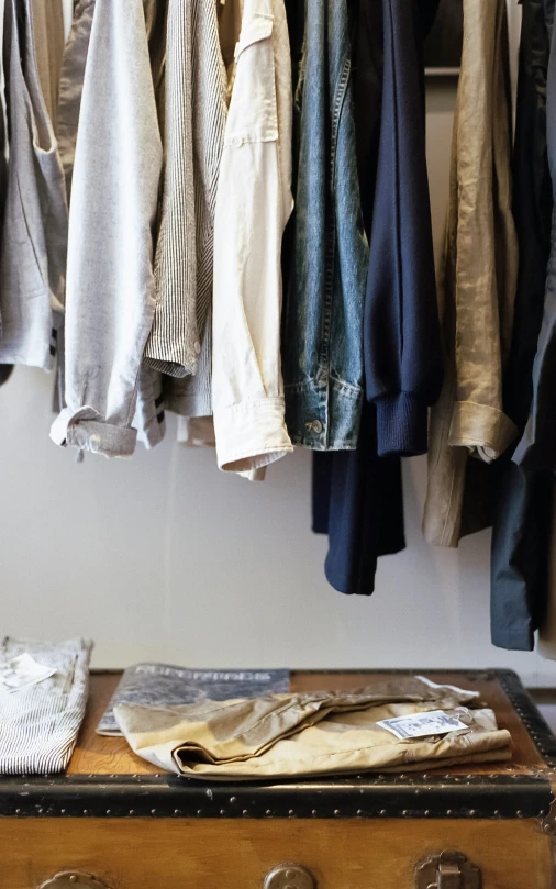 a trunk is filled with clothes and clothing hanging on hooks