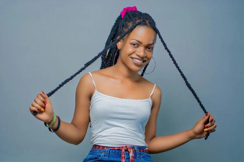 a girl with two large twists standing next to a wall