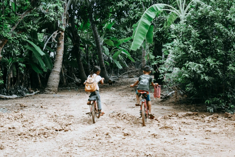 two people riding bikes on a dirt trail
