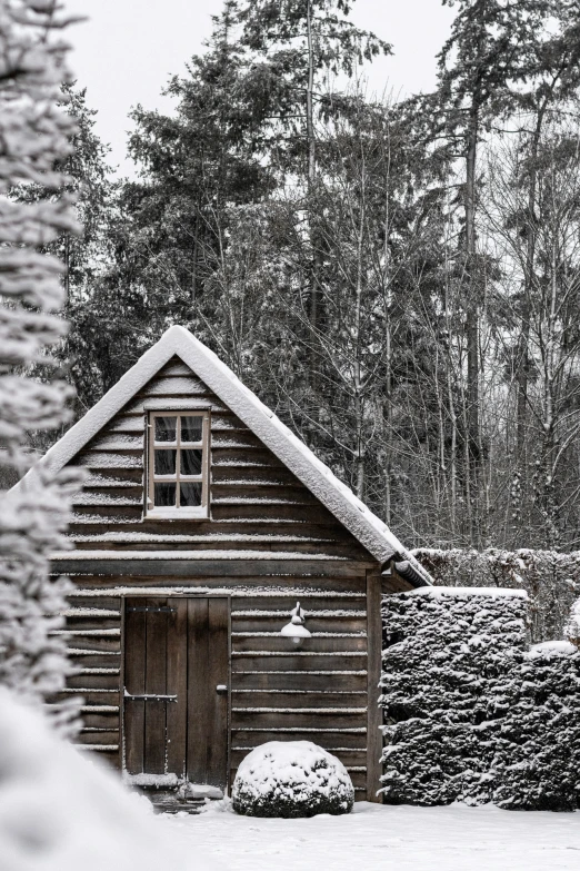 a log cabin next to a fence with snow on the ground