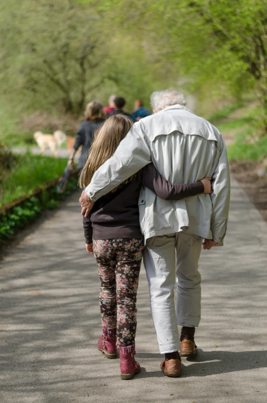 a couple walking down a path while another person holds their back