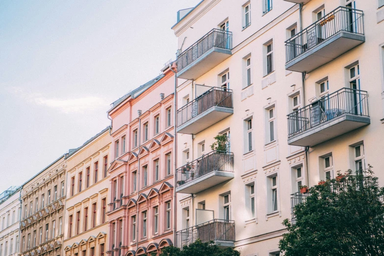 a city sidewalk lined with several different multi - story apartment buildings