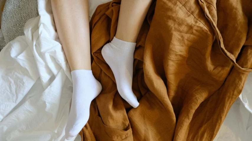 the legs and ankles of a person lying on a bed