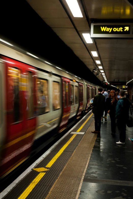 a train pulling into the subway station with people on the platform