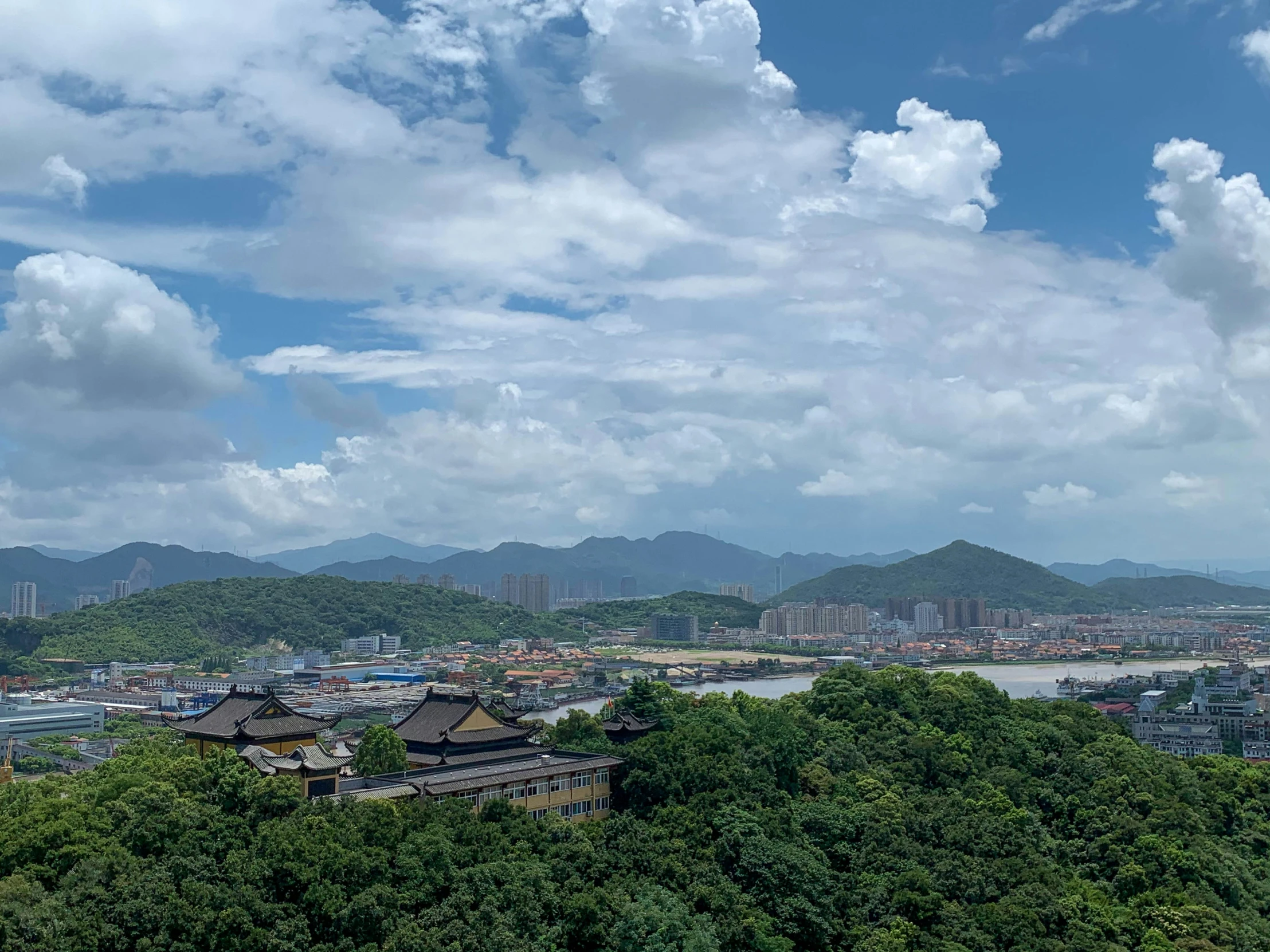 a view from the top of a hill with mountains in the background