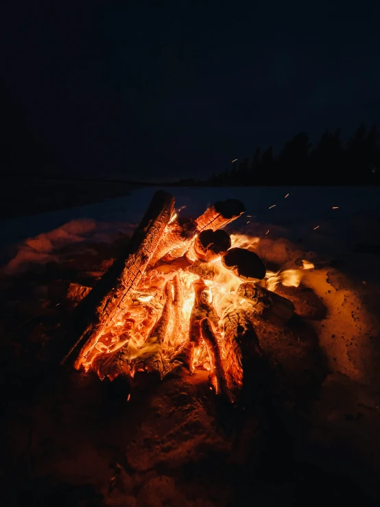 a glowing fire in the snow during a dark night