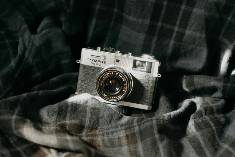 an old camera sitting on top of a bed