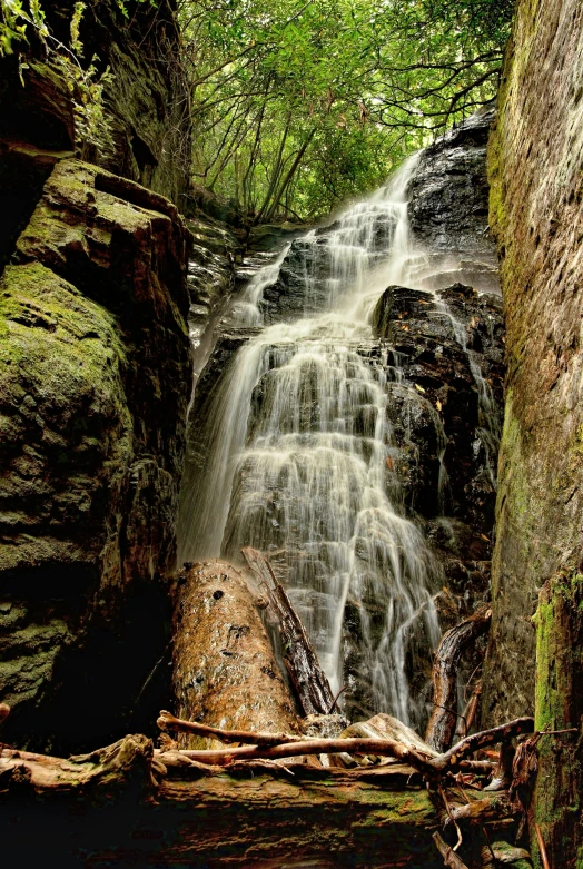 a couple of large rocks in front of a waterfall