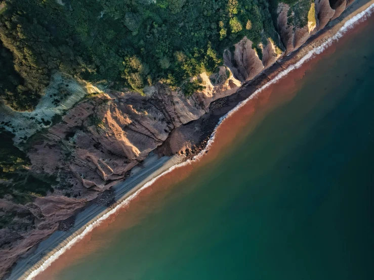 an aerial view of the shore and sea with clear water