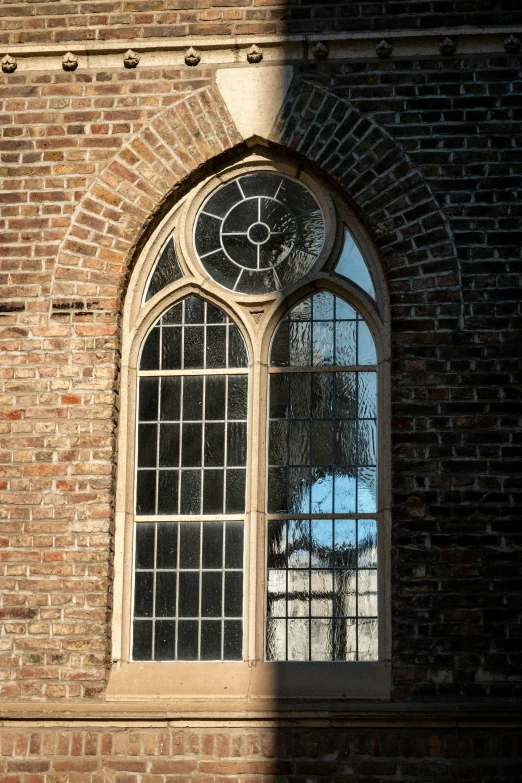 an arched window in a brick wall with clear glass