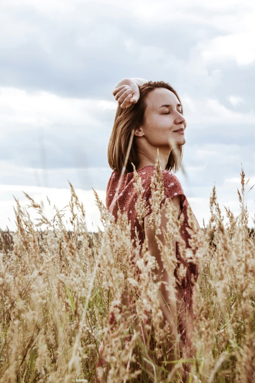 the woman is standing in a field of tall grass