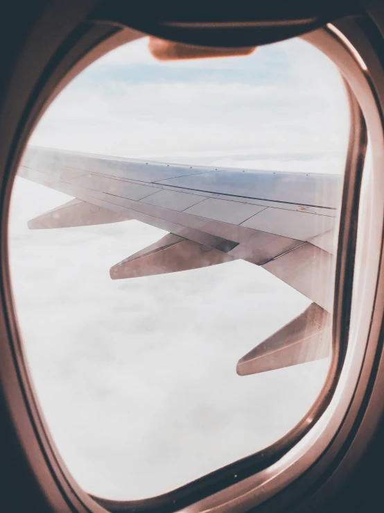 airplane wing view over clouds and the sky