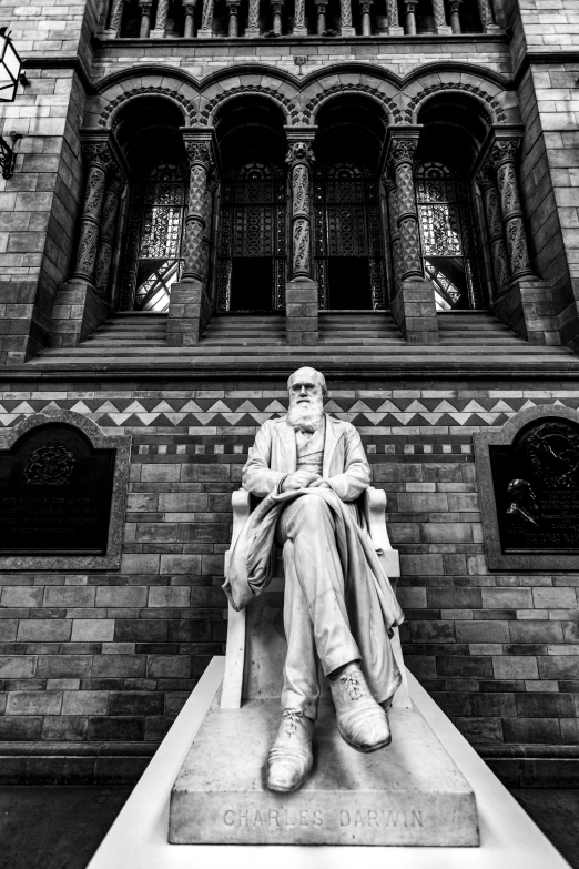 a man sitting on top of a statue in front of a building