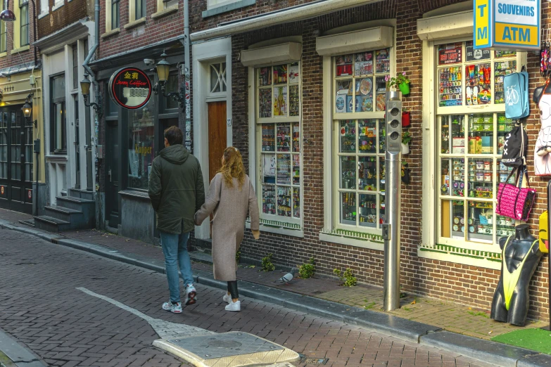 two people walk outside the front of a store