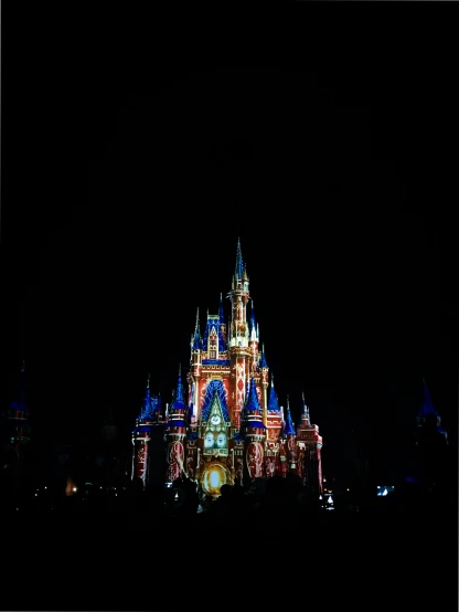 an illuminated castle stands in the darkness