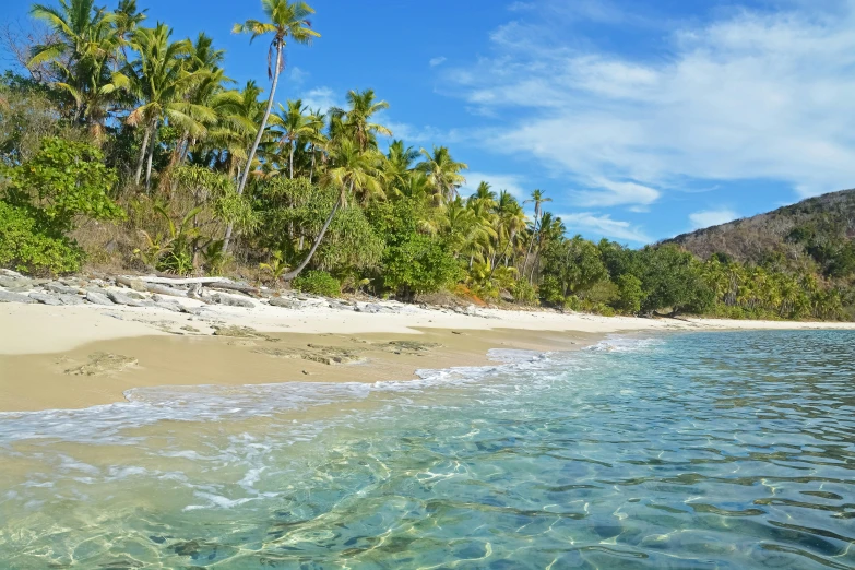 the blue water of the ocean with a sandy beach near it