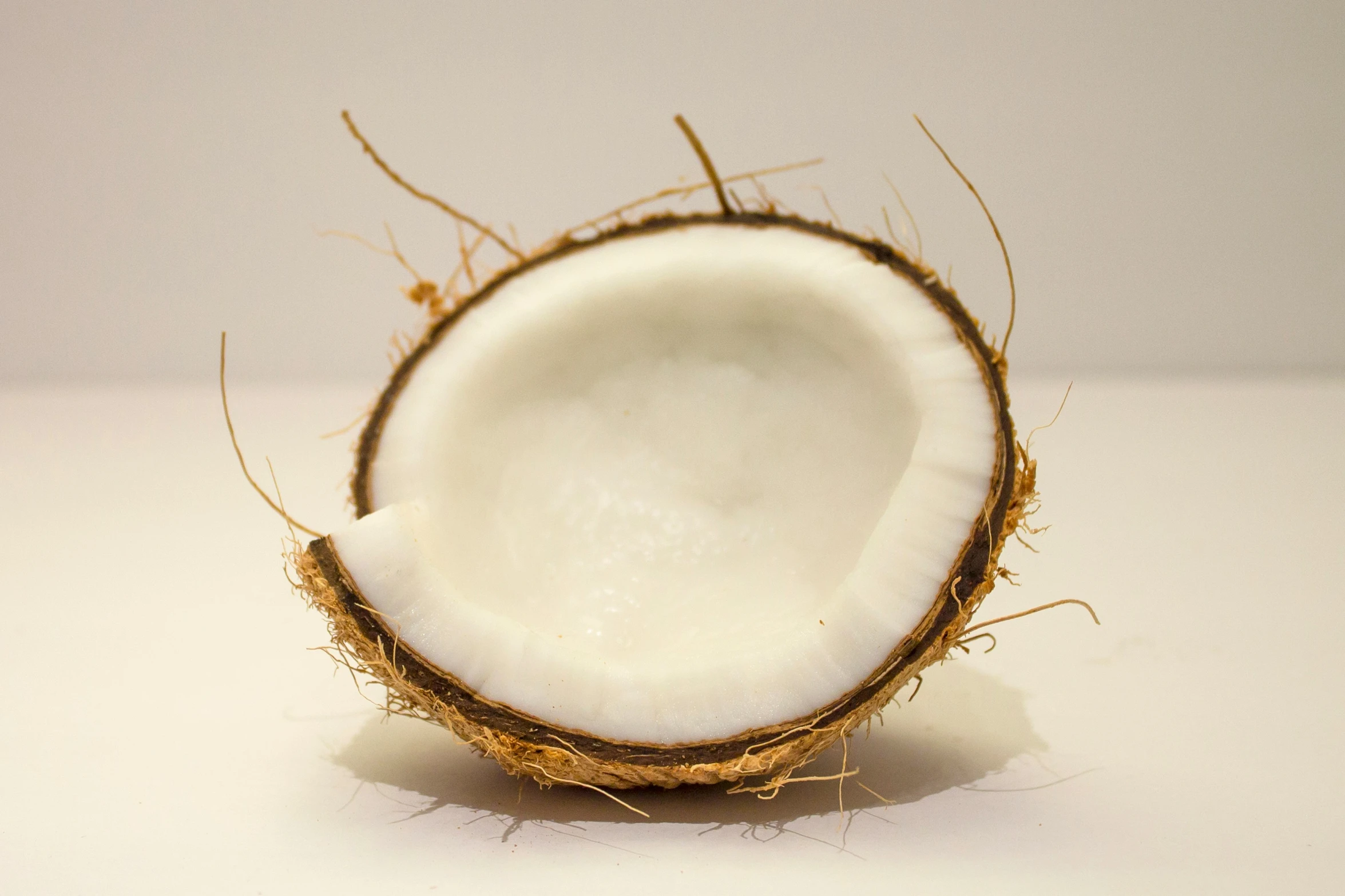 a coconut on white background next to a banana peel