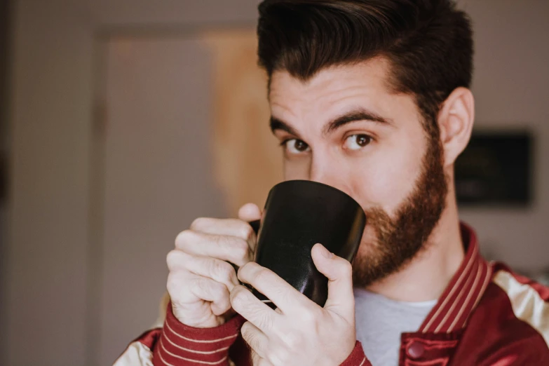 the man is using a cup to drink from the same cup