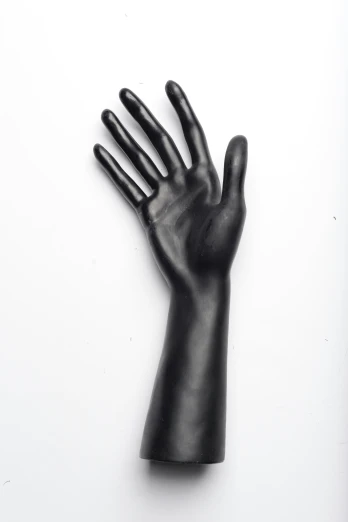 a large black plastic hand on a white surface