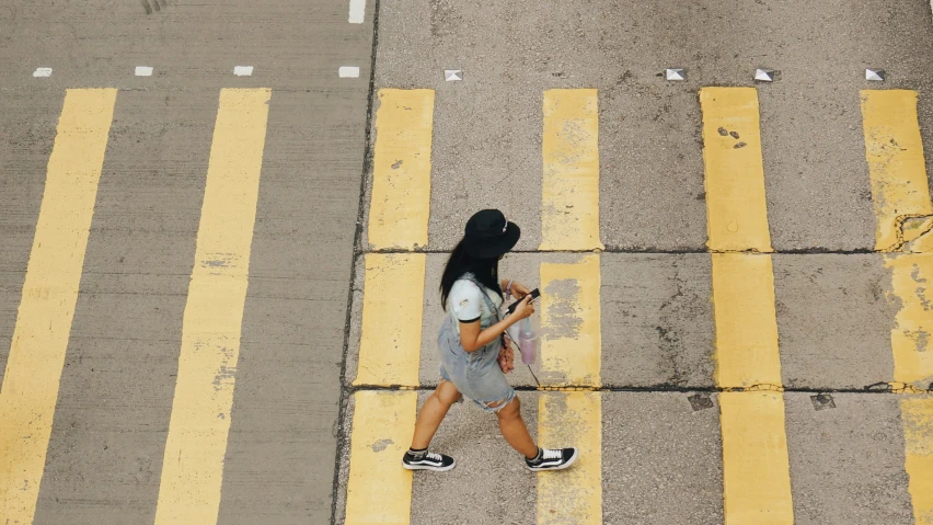 the woman is crossing the cross walk on the street