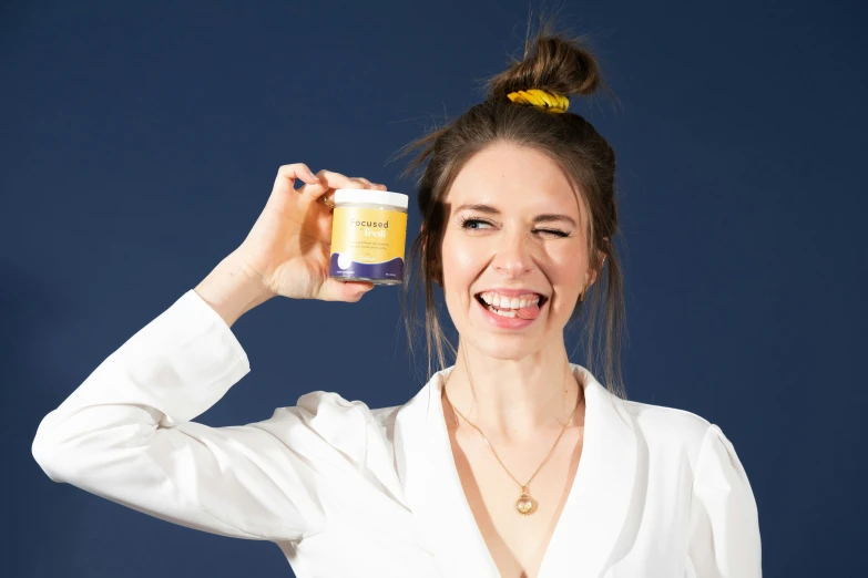 a woman holding up a jar of cream to her hair