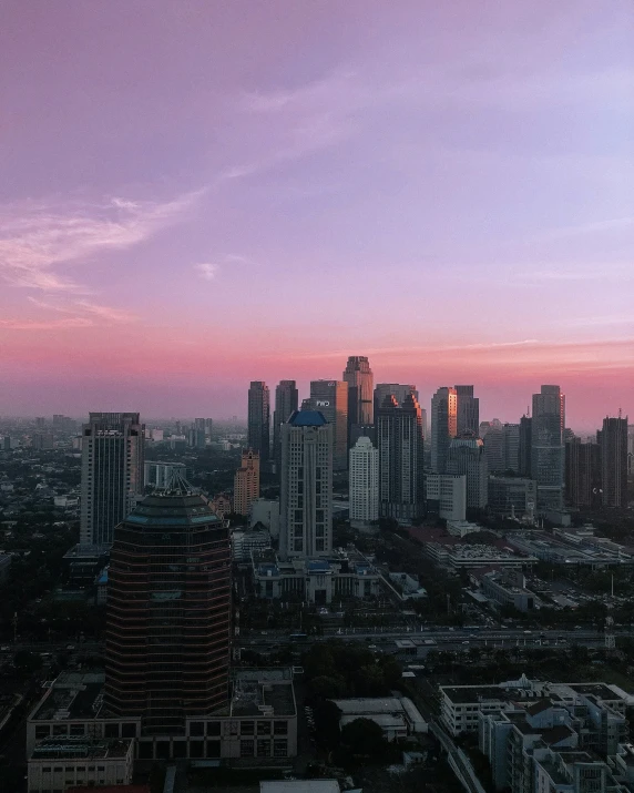 a cityscape is pictured with a pink sky