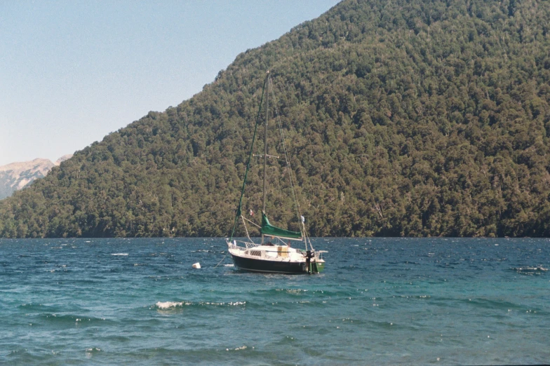 a boat out on the water and mountains behind it