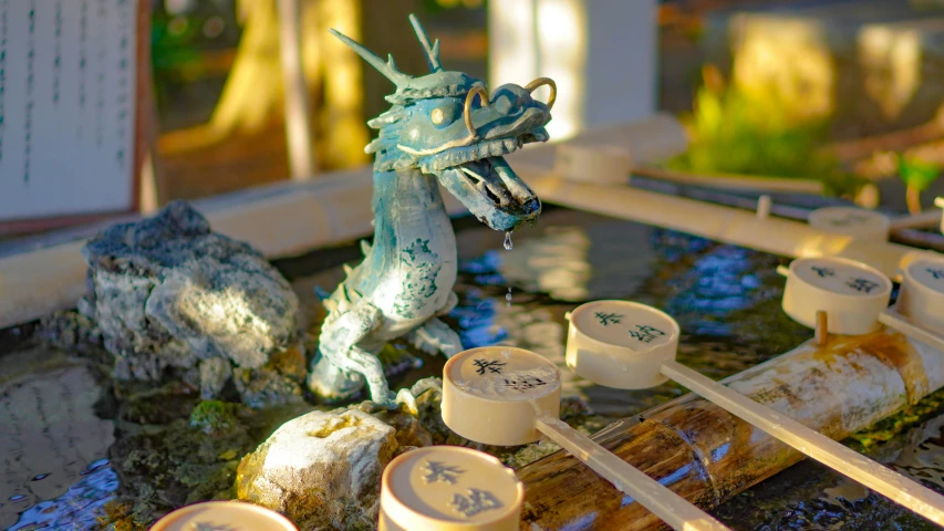 several bottles and containers of food sitting in front of a dragon fountain