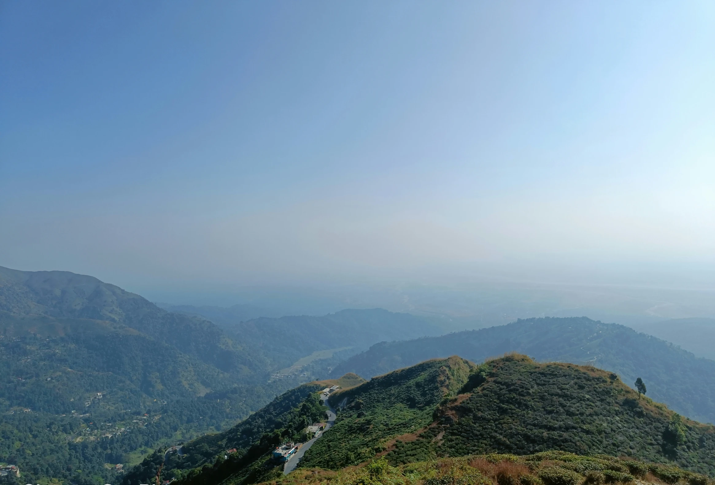 a mountain with a lush green valley and a valley below