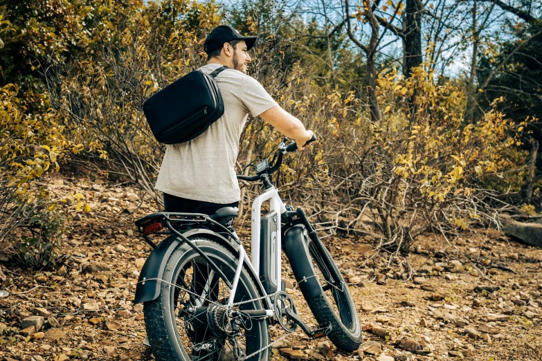 a man with a black backpack is on a bike