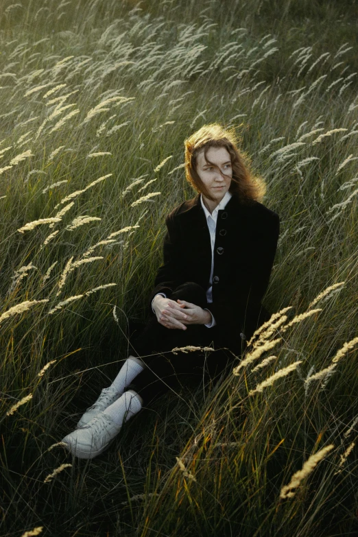 a woman is laying in the tall grass