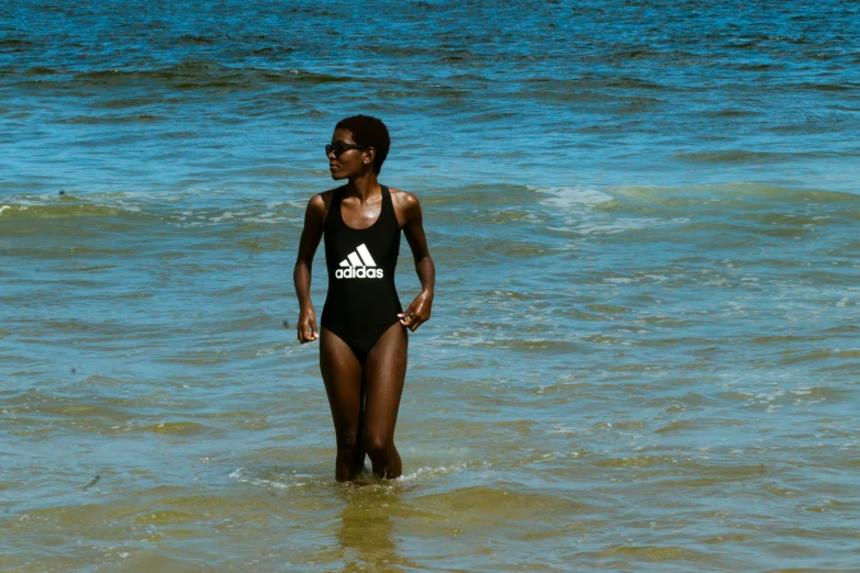 a woman is standing in the water with her feet crossed