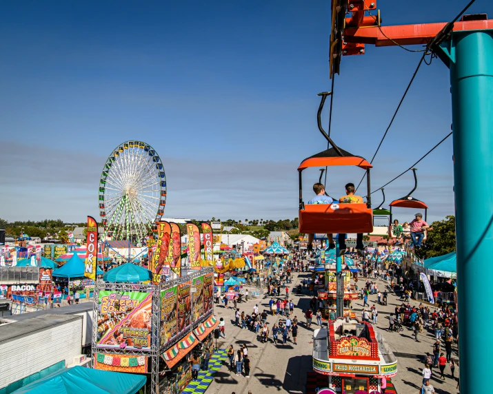 an carnival with several rides and a ferris wheel in the background