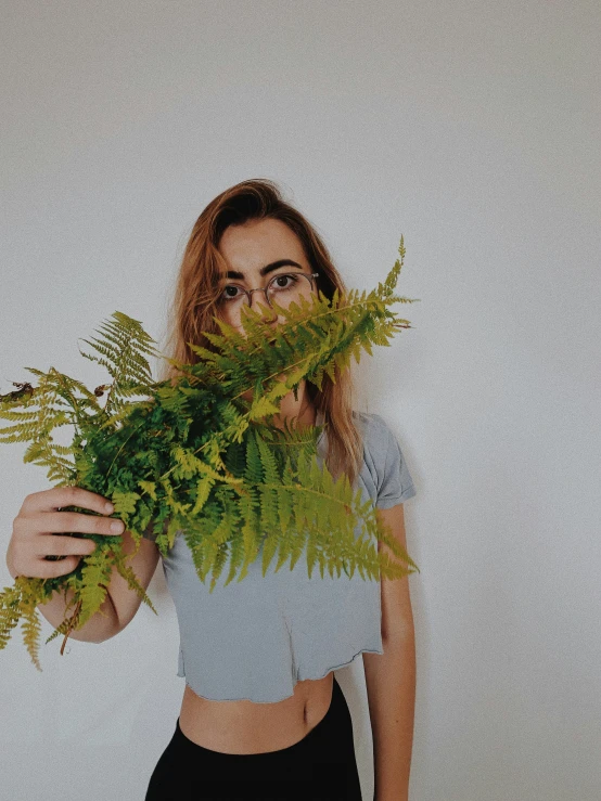 a woman holding a bunch of plants in her hand