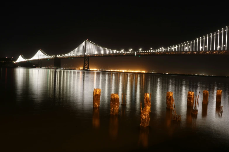 a very long bridge going over the ocean at night