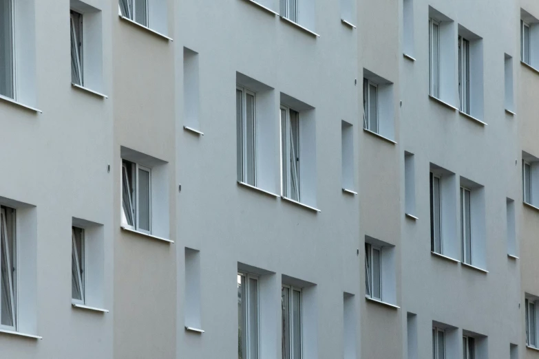 many windows are seen in the side of a grey building