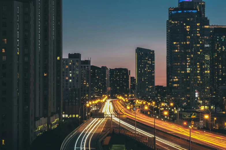 a street at night with a city in the distance