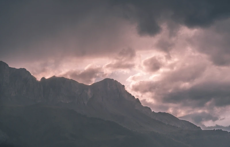 a mountain is obscured by dark clouds during the day