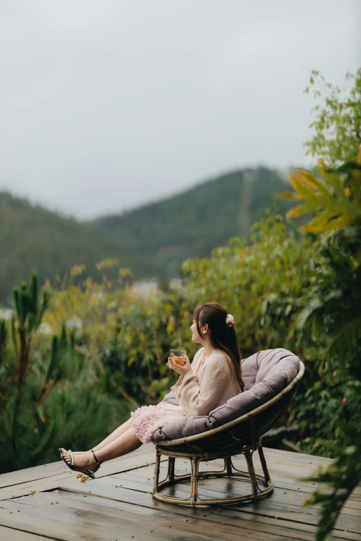 girl in white robe sitting on a brown lounge chair