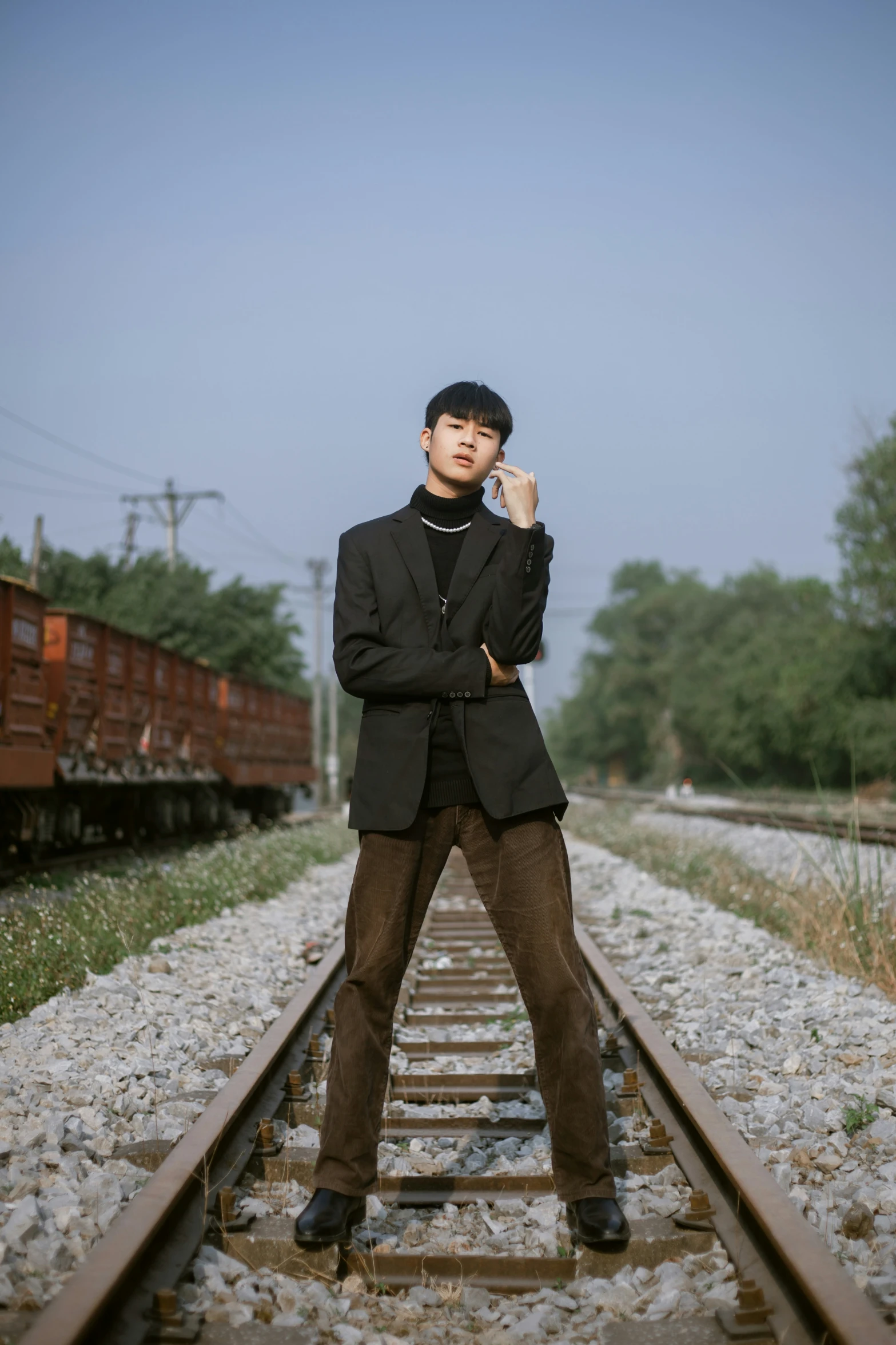 a man is posing for a po on railroad tracks