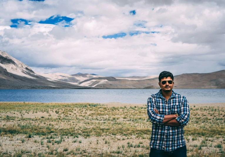 a man standing in front of the water in the desert