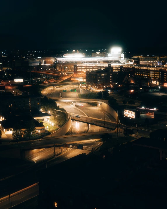 a night view of a highway going by a stadium