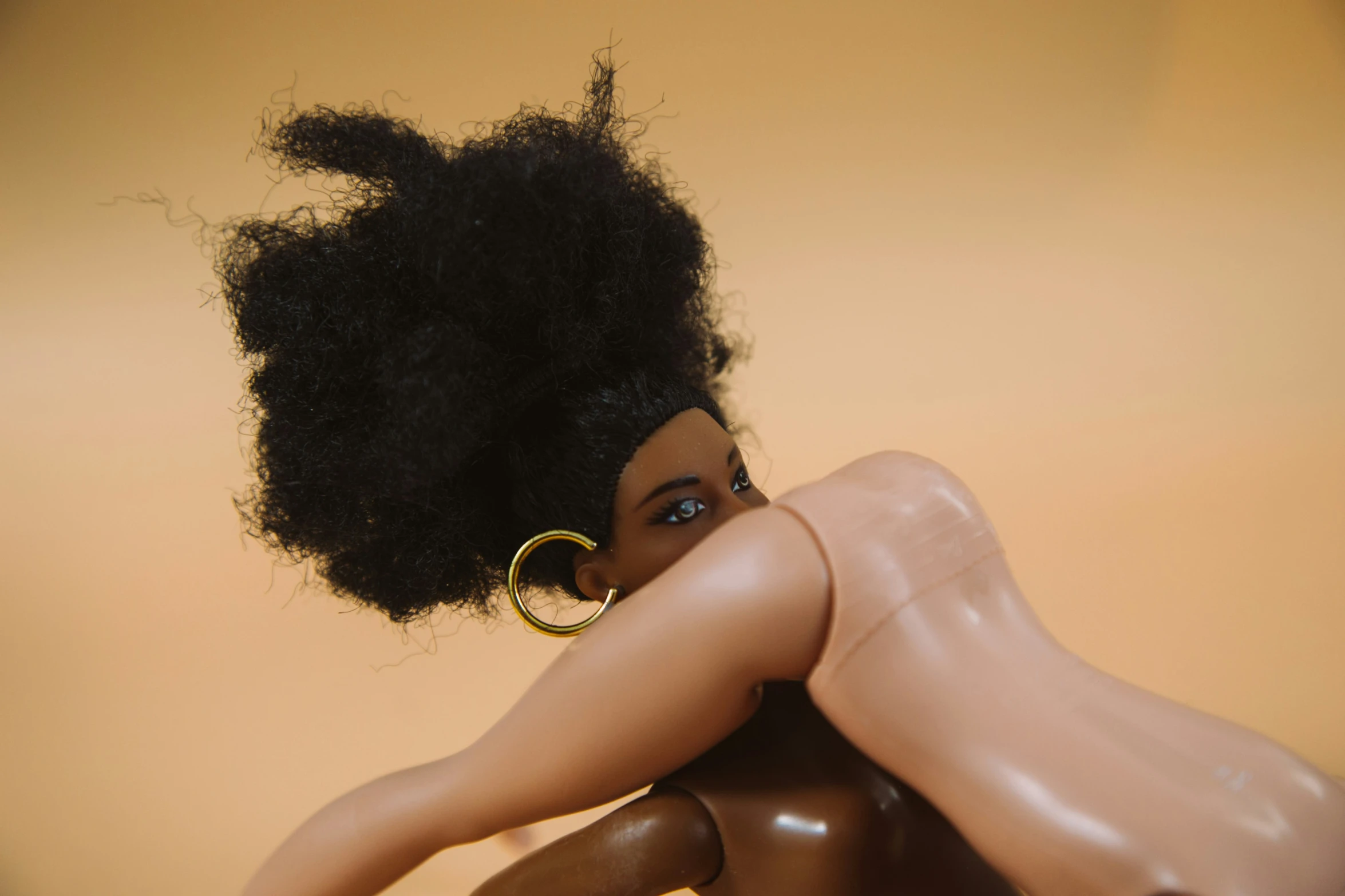 a  black doll with curly hair and hoop earrings