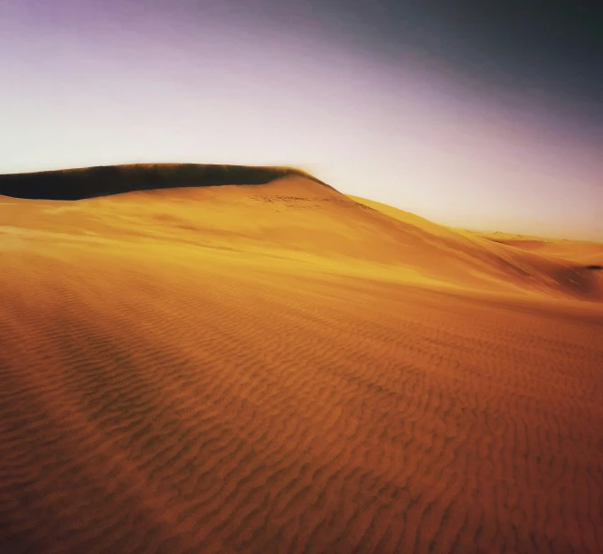 a very wide wide desert with a large hill in the background